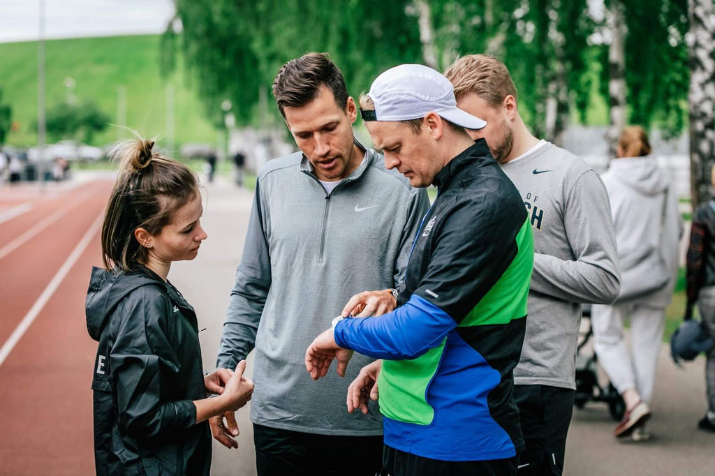 Jānis Višķers ar sportistiem pārbauda pulksteņa datus stadionā